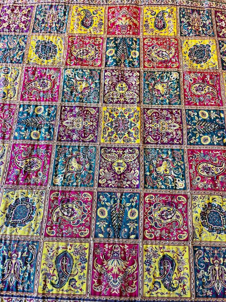 May include: A colorful quilt with a patchwork design featuring a variety of paisley patterns in shades of yellow, red, blue, and green.