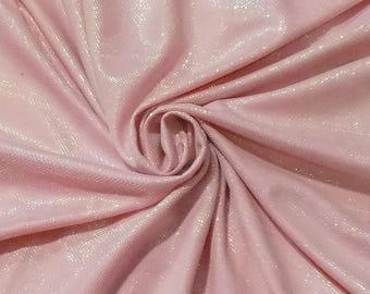 May include: Pink fabric with a subtle shimmer and a textured surface. The fabric is folded and draped to show its texture.