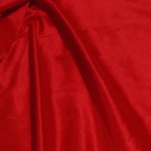 May include: A close-up of a smooth, red fabric with soft folds and wrinkles.