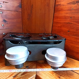 Vintage stove for cooking over an open fire with two burners running on kerosene. An old tourist or village stove running on kerosene.