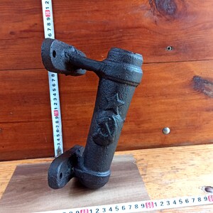Puede incluir: Soporte de pared de metal negro con un diseño de estrella decorativo. El soporte está hecho de hierro fundido y tiene un aspecto rústico.