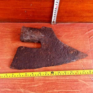 May include: A rusty, antique axe with a curved blade, measuring approximately 17 inches long. The axe is made of metal and has a wooden handle.