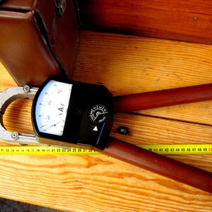Antique high-voltage clamp meter for measuring current without breaking the circuit. Historical artifact. Electrical measuring device.