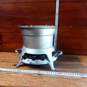 Vintage kerosene stove for cooking over an open fire with three burners. Historical artifact. Antique gift. Old tourist or country stove.