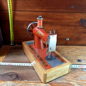 Vintage children&#39;s manual mechanical sewing machine. An old children&#39;s sewing machine. Kids toys. Children&#39;s gift.