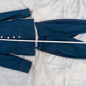 May include: A dark blue military uniform with gold trim and red piping. The uniform includes a jacket and pants.