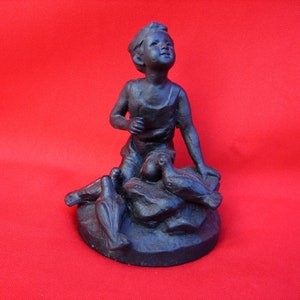 Antique cast iron figurine of a boy feeding pigeons. Old figurine - Boy and pigeons. Antique gift. A Christmas gift.