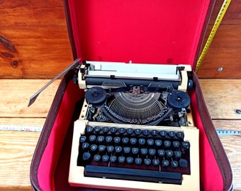 An old mechanical machine of an unknown company in its own suitcase. Historical artifact. Antique gift. Typewriters.