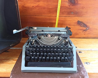 An old mechanical typewriter in its own suitcase. Historical artifact. Antique gift. Typewriters.