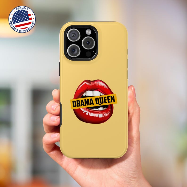 May include: A yellow iPhone case featuring a red and white lips design with a yellow banner that reads "Drama Queen".