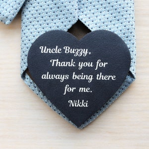 May include: A black heart-shaped chalkboard with the message "Uncle Buzzy, Thank you for always being there for me. Nikki" on a light blue patterned tie.