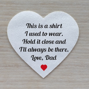 May include: White heart-shaped card with the text "This is a shirt I used to wear. Hold it close and I'll always be there. Love, Dad" and a small red heart.