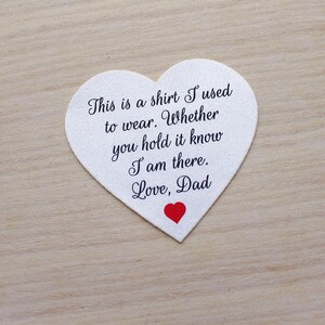 May include: A heart-shaped white fabric patch with black script that reads "This is a shirt I used to wear. Whether you hold it know I am there. Love, Dad." A small red heart is at the bottom.