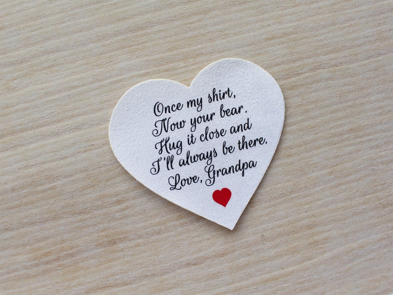 May include: A white heart-shaped card with the text "Once my shirt, Now your bear. Hug it close and I'll always be there. Love, Grandpa" in black script. A small red heart is at the bottom.
