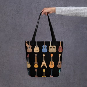 May include: A black tote bag with a colorful pattern of various guitars, including acoustic, electric, and ukulele styles.