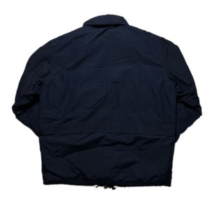 May include: A dark blue jacket with a zipper closure and a drawstring at the bottom.