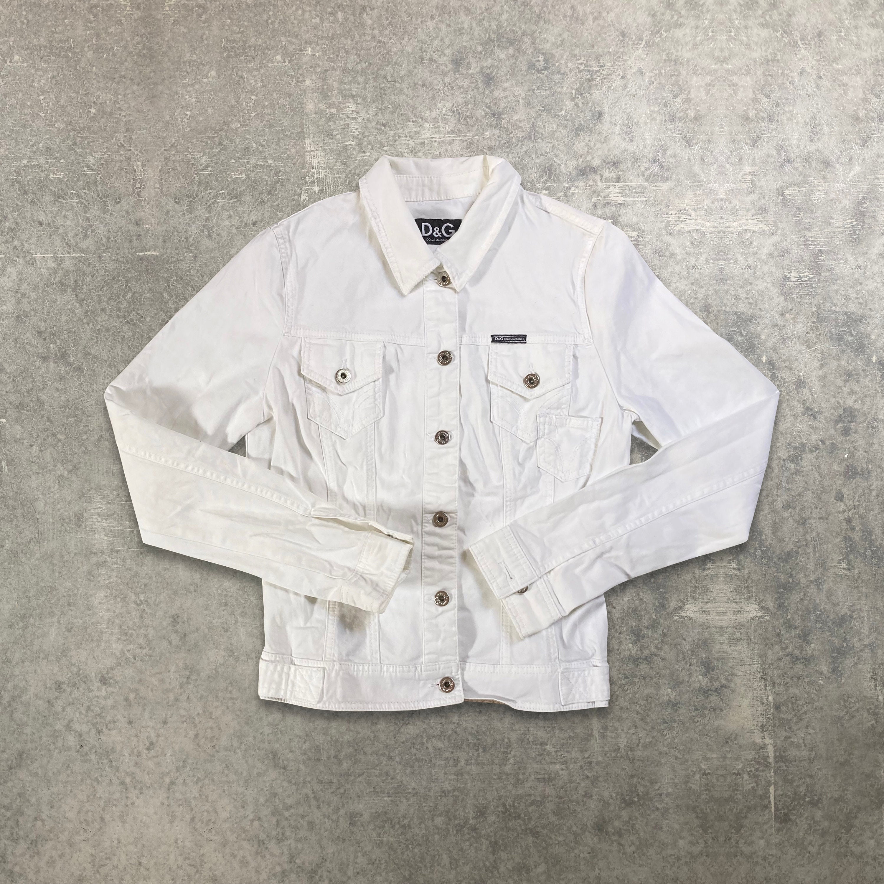 A $1,195 white peak-lapeled cotton jacket by Dolce & Gabbana tops