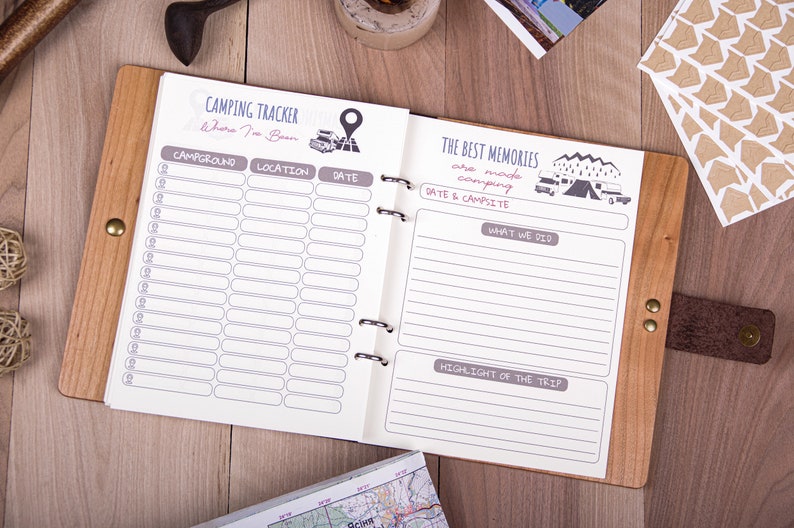 May include: A brown leather-bound journal with a wooden cover. The journal is open to a page with a camping tracker on the left side and a section for writing about camping memories on the right side. The journal has a title that reads "Camping Tracker" and "The Best Memories are made camping".