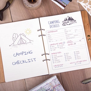 May include: A brown leather-bound notebook with a camping checklist and details on the inside pages. The checklist includes items like tent, sleeping bag, food, and water. The details page includes space for campground name, dates, amenities, and a star rating.