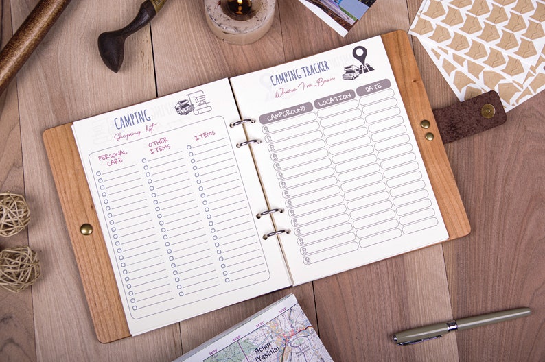 May include: A wooden-bound notebook with a white interior. The left page has a checklist titled "Camping Shopping List" with categories for "Personal Care" and "Other Items". The right page has a checklist titled "Camping Tracker - Where I've Been" with columns for "Campground", "Location", and "Date".