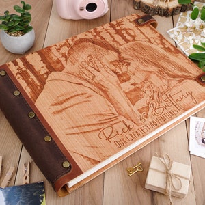 May include: A wooden photo album with a brown leather cover and a personalized inscription that reads "Rick & Brittany Our Greatest Adventures." The album features a laser-engraved image of a couple embracing.