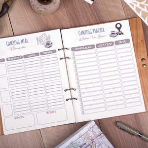 May include: A brown leather-bound journal with a white interior. The journal is divided into two sections: a camping meal planner and a camping tracker. The meal planner includes sections for breakfast, lunch, dinner, snacks, and drinks. The camping tracker includes sections for campground, location, and date.
