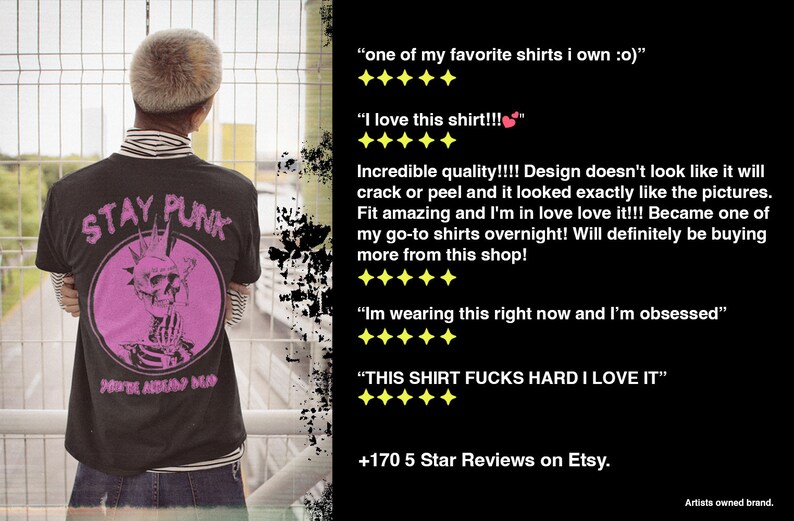 May include: Black t-shirt with a pink graphic of a skull with a mohawk and the words "STAY PUNK" and "NEVER ALWAYS DEAD". The person is wearing a striped long-sleeve shirt underneath.