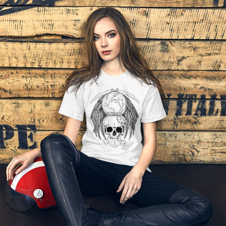 May include: White t-shirt with a black and white graphic print of a skull with wings, a scythe, and a globe. The graphic is centered on the shirt.