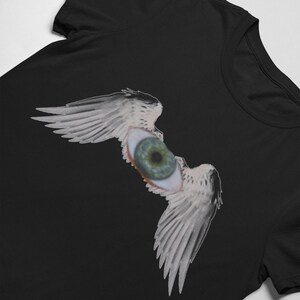 May include: Black t-shirt with a graphic of a large eye with wings. The eye is green and the wings are white.
