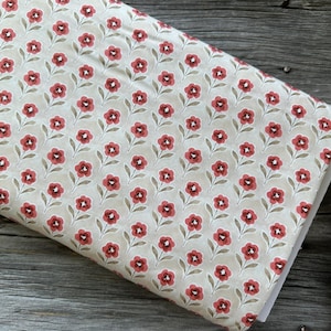 Pode incluir: Um tecido bege com um padrão repetido de pequenas flores vermelhas e caules verdes.