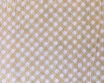 Puede incluir: Una tela con un patrón repetitivo de cuadrados blancos y amarillo-verdosos claros, creando un diseño de cuadros o cuadros. La tela parece ligeramente arrugada, lo que sugiere que está hecha de un material suave como el algodón o el lino.