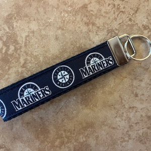 May include: Black and white Mariners key chain with a compass logo and the word "Mariners" repeated on the strap.