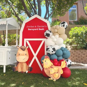 Może przedstawiać: Dekoracje na przyjęcie w stylu wiejskim z czerwonym tłem stodoły i napisem "Jordan & Xavier's Barnyard Bash". Obejmuje konia z kreskówek, kurę z pisklęciem i łuk balonowy.