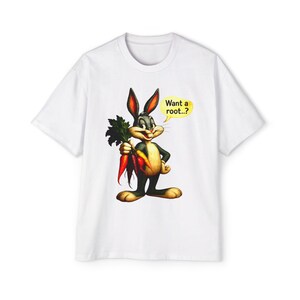 May include: White t-shirt featuring Bugs Bunny holding carrots. The cartoon rabbit is depicted in a classic pose with a yellow speech bubble that reads "Want a root..?"