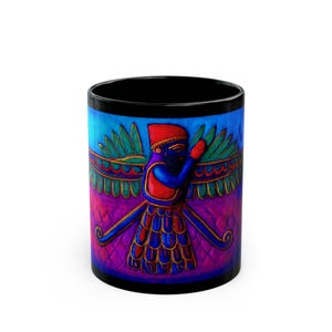 May include: Black ceramic mug featuring a colorful illustration of a winged figure with a red hat and blue and gold accents. The design is set against a gradient background of blue, purple, and pink hues. The mug has a black interior and rim.