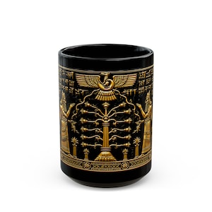 May include: A black cylindrical mug featuring a detailed gold-colored relief design. The artwork depicts two figures flanking a central tree, topped by a winged solar disc symbol. Intricate cuneiform-style script borders the top and bottom edges.