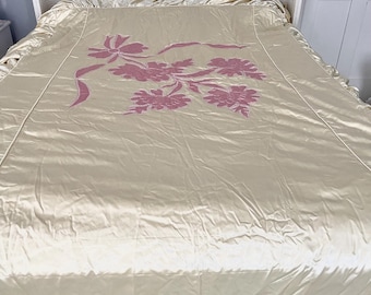 Preciosa colcha de tafetán de seda forrada de algodón, color amarillo mantequilla, con bordado de cinta rosa, de los años 50, con volantes y almohada. 6 piezas.