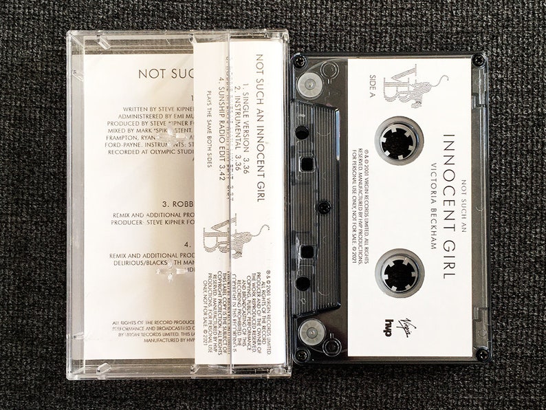 May include: A clear cassette tape case with a black cassette inside. The cassette label reads "NOT SUCH AN INNOCENT GIRL" by Victoria Beckham. The case also displays the track listing and production credits.