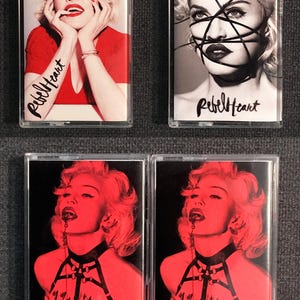 May include: Four cassette tapes featuring Madonna's Rebel Heart album art. The images include portraits of Madonna in various poses, with the album title written on the tapes. The color schemes vary from black and white to red.