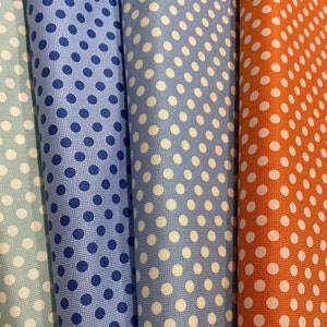 May include: Three fabric swatches with white polka dots on a blue background. The swatches are in different shades of blue and orange.