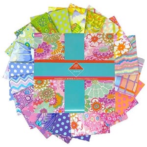 May include: A selection of patterned fabric squares in a circular arrangement. The fabrics display floral, polka dot, and abstract designs in pink, green, blue, and orange hues. A turquoise ribbon is wrapped around the centre, with text on a label.