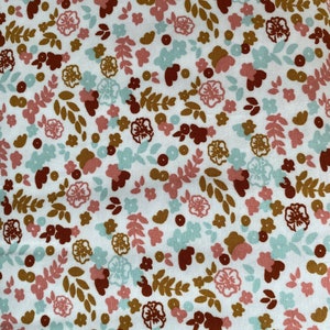 May include: White fabric with a repeating pattern of small brown, pink, and blue flowers and leaves.