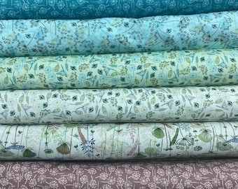 Può includere: Un rotolo di tessuto con un motivo floreale. Il tessuto è di colore blu chiaro, verde e marrone su uno sfondo bianco. Il motivo è composto da piccoli fiori e foglie.