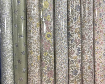 Può includere: Una collezione di sei campioni di tessuto con motivi floreali. I tessuti sono in varie tonalità di rosa, blu e verde.