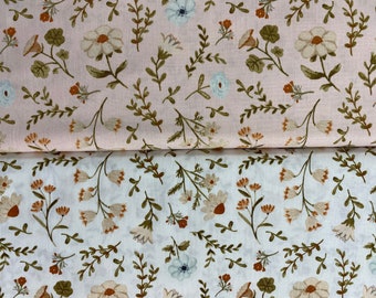 Può includere: Primo piano di due pezzi di tessuto con un motivo floreale. Il tessuto superiore è rosa con fiori bianchi e il tessuto inferiore è bianco con fiori marroni.