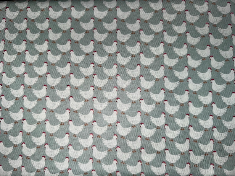 Puede incluir: Una tela blanca con un patr&oacute;n repetitivo de pollos blancos sobre un fondo azul claro.