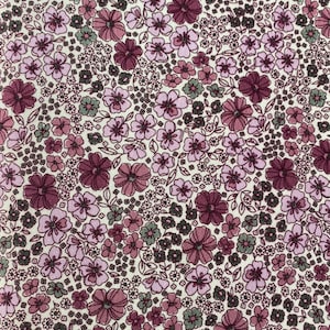 May include: A white fabric with a repeating pattern of small pink and purple flowers with green leaves. The fabric has a vintage feel.