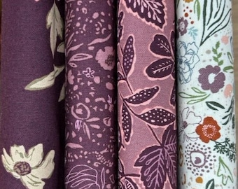 Può includere: Primo piano di quattro rotoli di tessuto con motivi floreali e a foglie. La tavolozza dei colori comprende sfumature di viola, rosa e bianco. I disegni presentano vari motivi floreali e fogliari, adatti a progetti di cucito e artigianato.
