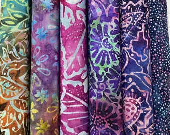 May include: Five fabric swatches with a batik pattern in shades of purple, pink, blue, and green. The fabric has a floral design.