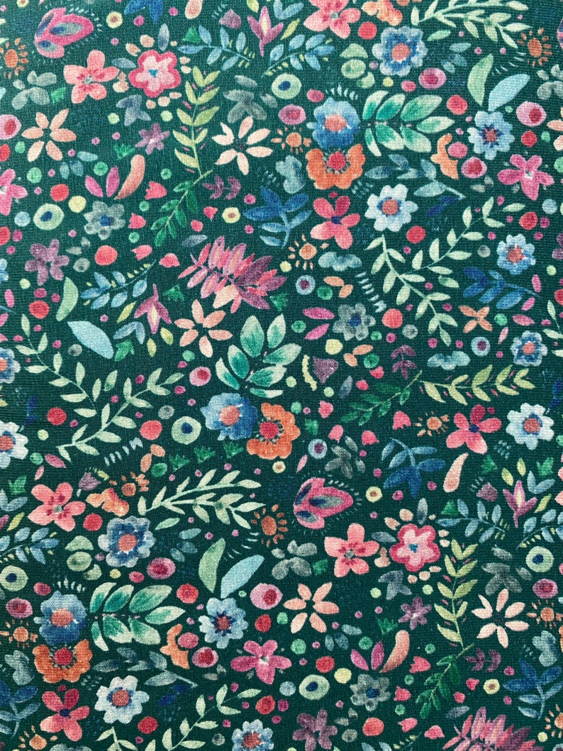 May include: A teal fabric with a repeating pattern of colorful flowers and leaves. The flowers are in shades of pink, red, blue, and yellow. The leaves are green and white.